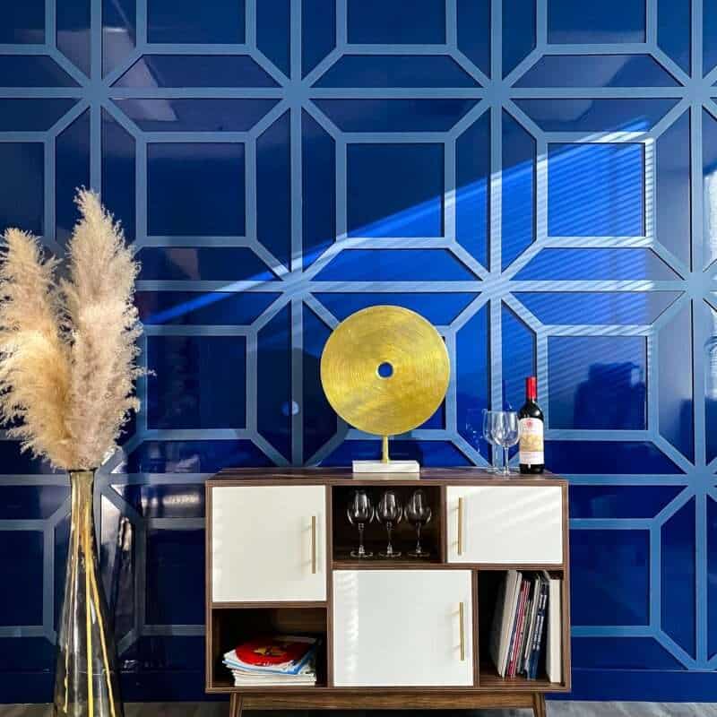Navy blue high-gloss accent wall with a mirror-like finish, complemented by matte trims, in a high-gloss painted room.