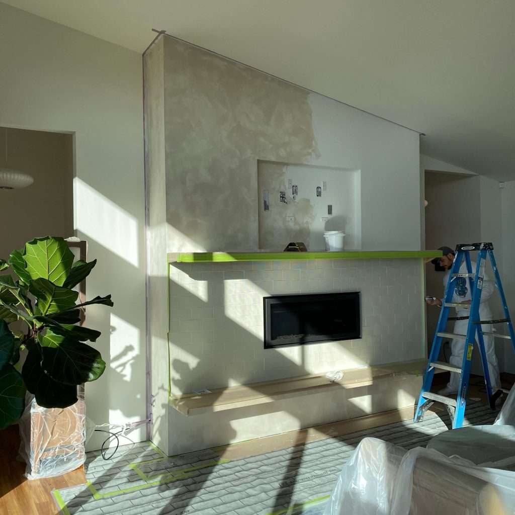 Work in progress on accent fireplace with Roman clay
