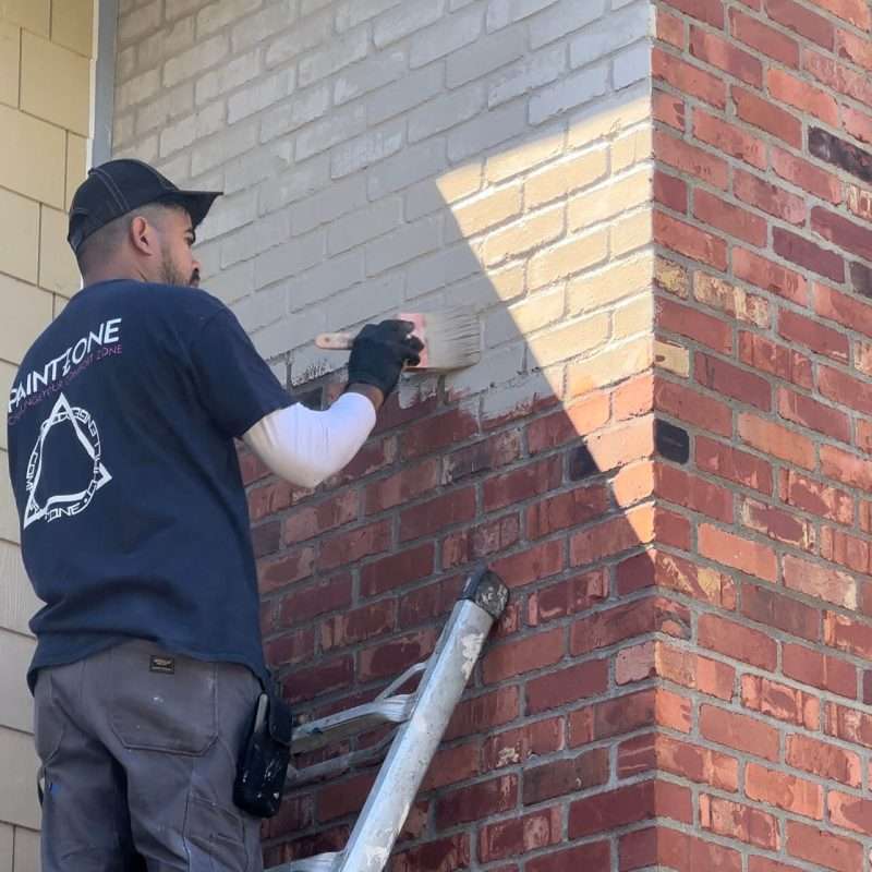 Brushing limewash on exterior house brick